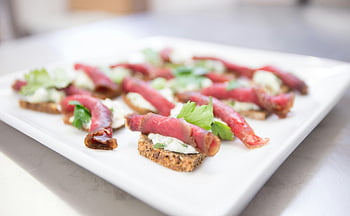beef carpaccio, creamy spread, toasted bread, garnished herbs, meat dish, vegetable dish, food photography, appetizer, gourmet food, culinary art, plate presentation