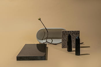 geometric objects, twig, minimalist composition, neutral background, brown surface, shapes, objects, abstract art, still life, modern design, sculpture