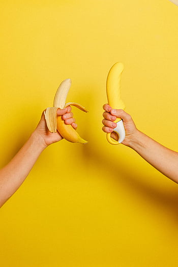 banană, Dildo galben, Configurare jucăușă, Fundal vibrant, Comparație creativă, mâinile exploatației, fundal galben, Comparație de fructe, Comparație de jucării, imagine jucăușă, culori vibrante