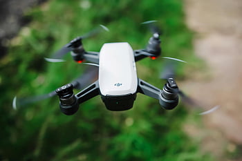 Black And White Quadcopter Drone, high-quality image, drone flying, blurred green grass, modern technology, DJI drone, quadcopter, aerial photography, outdoor technology, flying drone, green landscape