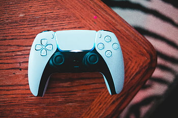 weißer Gamecontroller, Nahaufnahme, Holztisch, Gaming -Enthusiasten, stylischer Controller, Spielzubehör, Videospiel-Controller, Gaming-Ausrüstung, Controller -Design, Spieltechnologie, ergonomischer Controller