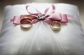 Eheringe, Seidenkissen, rosa Schleife, Herz Dekoration, Liebessymbol, selektiver Fokus, Verlobungsring -Set, elegante Ringe, Nahaufnahmen, rosa Bogenakzent, Dekokissen