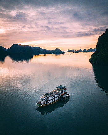 Trajekt v zálivu za úsvitu, záliv Halong, Vietnam, výletní loď, svítání, klidné vody, dron výstřel, Bay za úsvitu, Navigace na výletní lodi, vietnam travel, fotografie východ slunce