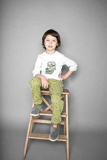 chlapec, sedící, béžová dřevěná stolička, roztomilé dítě, Stylový outfit, dřevěná stolička, Nastavení studia, zelené kalhoty, bílá košile, Šedé boty, studiové fotografie