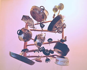 kitchen cookware, wooden rack, hanging utensils, artistic assortment, indoor display, cookware storage, kitchen organization, utensil rack, metal cookware, wooden utensil holder, kitchen tools