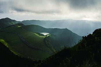 Lake in crater, extinct volcano, Azores Archipelago, São Miguel, scenic mountains, sunlight streaming, clouds, breathtaking view, green landscape, natural beauty, travel destination