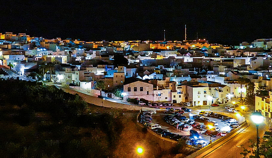 Nachtsicht, vejer, Spanien, Stadtbild, Nacht Lichter, Parkplatz, städtische Szene, Straßenlaternen, Wohngebäude, Stadt am Hang, mediterrane Architektur
