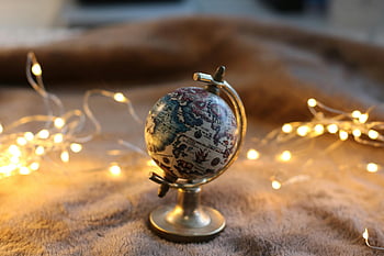 mini globe, decorative globe, glowing string lights, miniature globe, artistic display, globe decor, string lights, home decor, globe art, miniature world, globe ornament