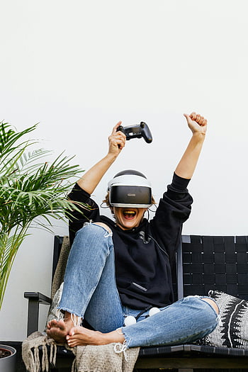 vr fejhallgató, játékvezérlő, nő ünnepli, fekete kapucnis, beltéri játék, virtuális valóság, alkalmi játék, nyugodt játék, játékvezérlő a kezében, izgatott játékos, beltéri szórakozás