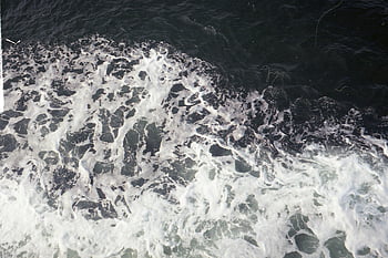 ocean waves, white foam, rippling sea, dynamic waves, nature's movement, aerial view, powerful waves, sea surface, ocean foam, wave texture, water movement