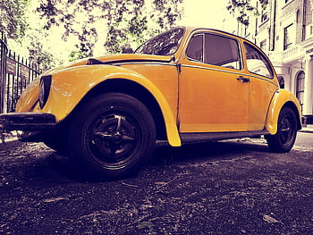 yellow Volkswagen Beetle, classic car, vintage car, street parked, nostalgic vibe, yellow Beetle, vintage Beetle, classic Beetle, Volkswagen Beetle coupe, closeup photo, vintage auto