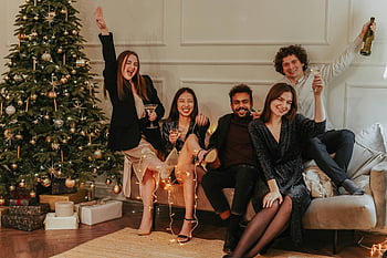 friends party, New Year's party, Christmas tree, indoor celebration, group of friends, drinks, festive gathering, holiday party, cozy setting, decorated tree, celebration drinks