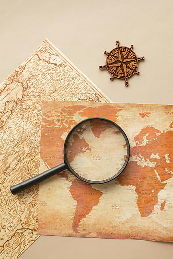 vintage map, magnifying glass, wind rose, compass, exploration themes, high-angle view, world map, antique map, navigation tools, travel concept, discovery theme