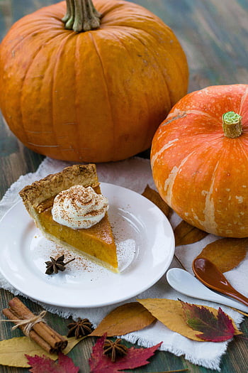pumpkin pie, whipped cream, white ceramic plate, autumn leaves, fall celebrations, sliced pumpkin, ceramic plate, pumpkin slice, fall dessert, seasonal treat, festive food
