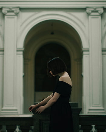 Žena v černých šatech, držení zábradlí, klasická architektura, oblouky, rozmazané pozadí, černé šaty, žena stojící, Architektonické oblouky, Foto titulek, Popis fotografie, žena poblíž oblouků