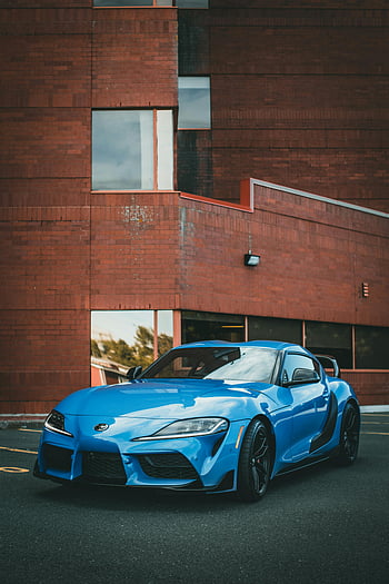 Blue Sportscar, toyota supra, zaparkováno, cihlová budova, elegantní design, lesklá modrá, auto, vozidlo, městském prostředí, moderní architektura, automobilového designu