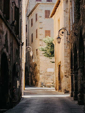 old European town, tranquil alleyway, soft sunlight, nostalgic ambiance, historic architecture, cobblestone street, vintage street lamps, European charm, narrow streets, old buildings, peaceful scene
