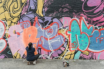 naisgraffititaiteilija, spray-maali, kaupunkiseinä, värikkäät graffitit, katutaide, spray-tölkit, seinämaalaus, ulkoilutaide, luova ilmaisu, kaupunkitaide, naisartisti