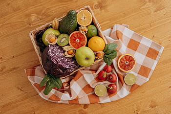 assorted fruits, brown woven basket, colorful mix, fruits and vegetables, rustic wooden table, checkered cloth, fresh produce, healthy eating, natural ingredients, vibrant colors, organic food