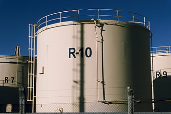 white industrial containers, large industrial storage tanks, metal structures, blue skies, industrial tanks, storage tanks, industrial containers, outdoor storage, industrial facility, industrial equipment, R-10