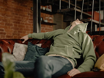 homme, Sweat à capuche vert, canapé en cuir, atmosphère confortable, décontracté, maison, relaxant, un jeune homme, canapé vert, décontractée, cadre intérieur