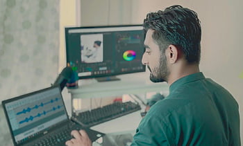 man editing, dual monitors, editing tools, professional setup, office work, editing software, laptop, dual displays, audio editing, video editing, workspace