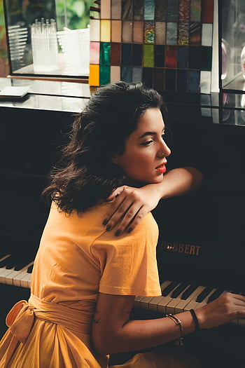 woman in yellow dress, black piano, relaxing, elegance, mood, Dobbert piano, indoor setting, artistic pose, stylish outfit, musical instrument, vintage aesthetic