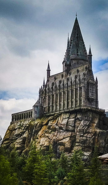 Hogwarts Castle, Universal Studios, California, dramatic view, towering castle, Harry Potter, theme park, castle architecture, rocky cliff, fantasy landmark, Universal Studios Hollywood