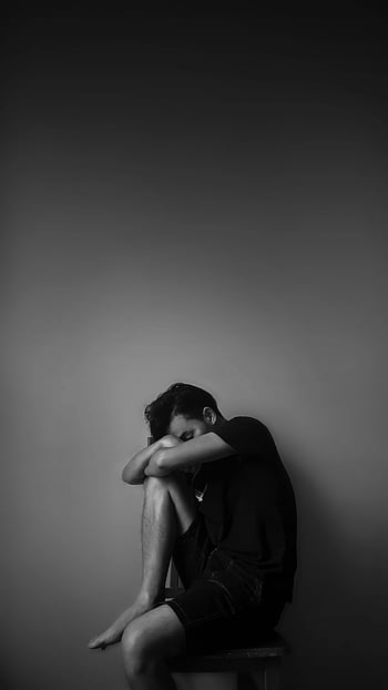 grayscale photography, man sitting, beside wall, black and white, portrait, alone, emotion, contemplation, monochrome, solitude, melancholy