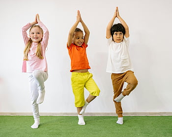 active children, balancing exercises, diverse children, practicing yoga, indoor yoga, joy and balance, children yoga, kids yoga, balance exercises, indoor activities, diverse kids