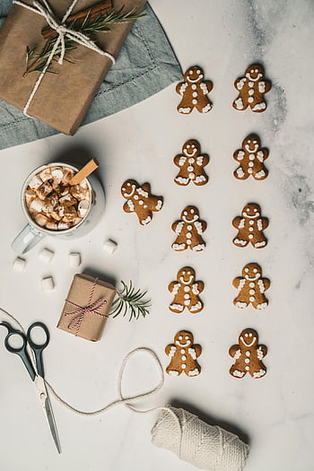 gingerbread cookies, marshmallow drink, holiday decorations, Christmas spirit, overhead shot, gingerbread men, festive treats, winter scene, gift wrapping, hot cocoa, seasonal treats