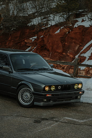 bmw e30, BMW vintage, Fiochi gialli, auto parcheggiata, strada foderata di neve, Design automobilistico classico, scena invernale, bmw nero, lato della strada, macchina classica, macchina vintage