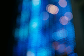 abstract blue bokeh, dark background, circular shapes, dreamy atmosphere, blue light, bokeh effect, abstract photography, circular bokeh, blue circular bokeh, abstract art, dark backdrop