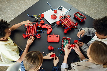 děti se učí elektroniku, praktické aktivity, robotické hračky, skupina dětí, vzdělávání v elektronice, stolní činnosti, Vzdělávací hračky, učení robotiky, Interaktivní učení, aktivity ve třídě, žena učí