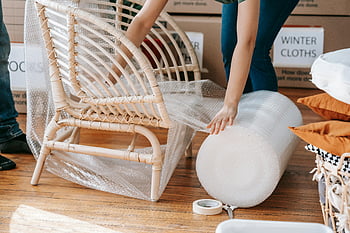 bubble wrap, wooden chair, moving out, person wrapping, packing materials, winter clothes, cardboard boxes, protective wrapping, home moving, furniture protection, bubble wrap roll