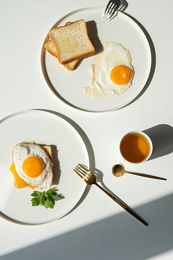 fried eggs, toast, white plates, minimalist breakfast, balanced composition, fresh start, sunny breakfast, simple breakfast, breakfast spread, morning meal, egg on toast