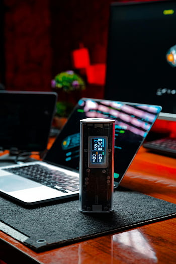 moderni työasema, kannettava tietokone, tekninen vempain, hämärästi valaistu, tyylikäs muotoilu, kehittynyt teknologia, työpöydän asetukset, digitaalinen näyttö, elektroninen laite, työtila, ympäristön valaistus