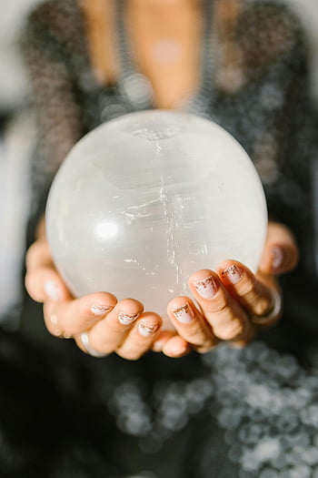 crystal ball, hands holding, clear crystal, spiritual themes, metaphysical themes, close-up photo, white round ball, person holding, crystal sphere, spiritual objects, metaphysical objects