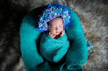 baby, blue blanket, newborn, flower crown, peaceful, soft surface, wrapped baby, vibrant flower, baby photography, baby portrait, blue wrap