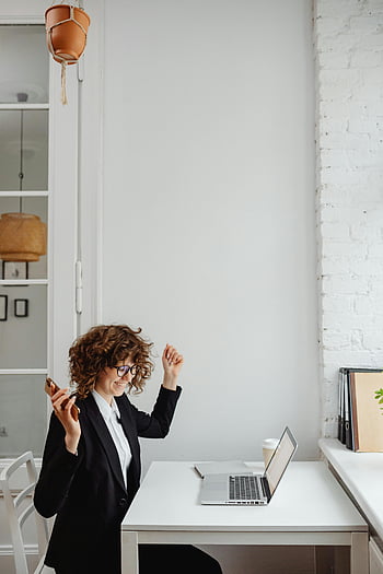femme d'affaires, blazer noir, cheveux bouclés, Célébrer le succès, appel téléphonique, bureau moderne, portable, bureau, professionnel, environnement de travail, réglage du bureau
