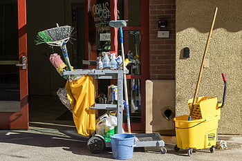 cleaning equipment, building entrance, sunlight, cleaning supplies, tools, mop, bucket, broom, cart, outdoor cleaning, commercial cleaning