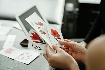 blom kort, röd blomma, tatueringstudio, närbild, vitt kort, röda skisser, studiomiljö, blommig design, konststudio, hålla handen, Kortdesign