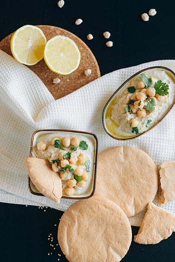 hummus, sliced lemon, fresh pita bread, chickpeas, creamy hummus, overhead shot, food photography, healthy eating, Mediterranean cuisine, appetizer, snack