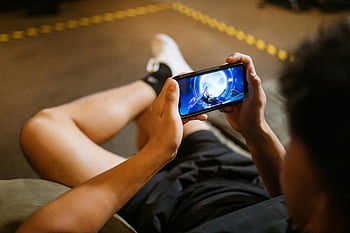 League of Legends Divoký Rift, Muž hrající videohra, Hraní smartphony, Vnitřní hraní, pohodlné hraní, mobilní hry, Přehrávač videoher, smartphone přehrávač, Vnitřní volný čas, Herní životní styl, příležitostné hraní