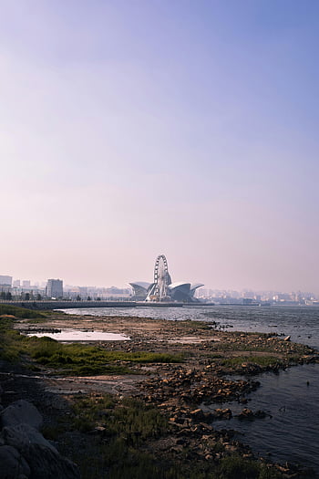 Caspian Sea, Baku waterfront, Ferris wheel, coastline, hazy skyline, scenic view, Baku cityscape, waterfront scenery, Caspian coastline, Baku attractions, hazy horizon