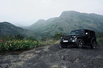 black Jeep, rugged terrain, mountain view, off-road adventures, black SUV, outdoor adventure, scenic landscape, adventure vehicle, natural scenery, mountainous area, off-road vehicle