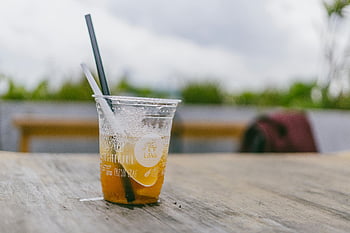 klare Plastikflasche, Eistee, Plastikbecher, Stroh, Holztisch, Erfrischung im Freien, Sommergetränk, kaltes Getränk, Outdoor-Einstellung, Erfrischungsgetränk, Kunststoffbehälter