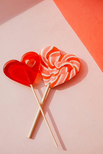 lízátko ve tvaru srdce, oranžová barva, Pastel Pink Surface, milovat, sladkost, cukroví, Valentýn, romantický, sladké dobroty, Symboly srdce, Lollipopové tyčinky