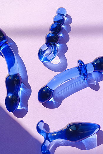 blue glass toys, pastel pink surface, stylish arrangement, adult toys, glass toys, blue glass, pastel pink, glass objects, blue objects, artistic arrangement, glass art