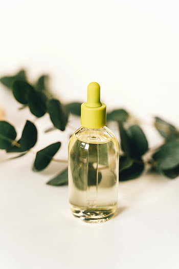 klar glasflaska, dropper, kosmetisk flaska, eukalyptusblad, mjuk bakgrund, närbild, gul droppare, eterisk olja, naturlig produkt, skönhetsprodukt, hudvård
